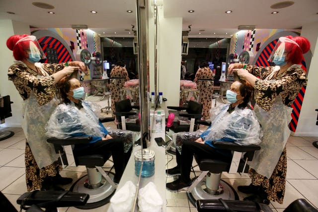 Carole Rickaby cuts the hair of customer Sandra Jacobs at Tusk Hair
