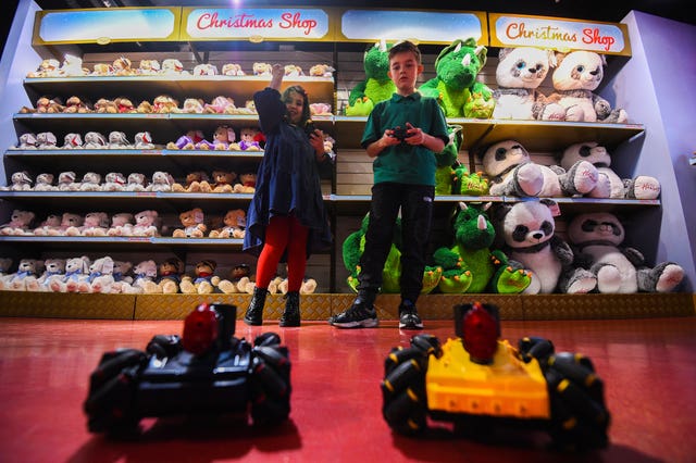Millie, eight, and Max, nine, play with Laser Battle Hunters during the Hamleys Christmas toy showcase at Hamleys, Regent Street, London