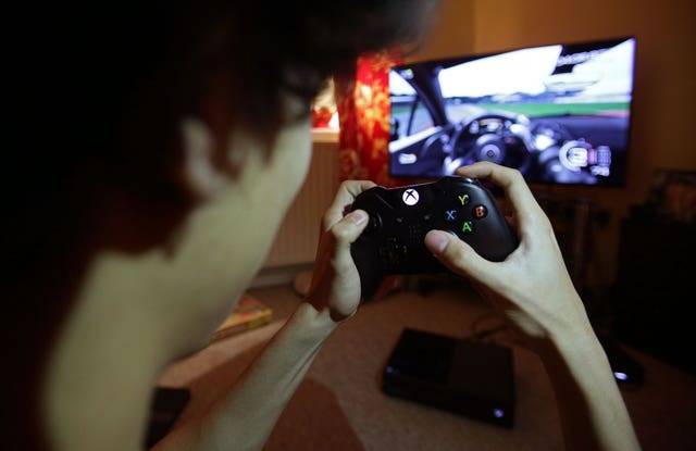 A teenager holding a controller to play a video game