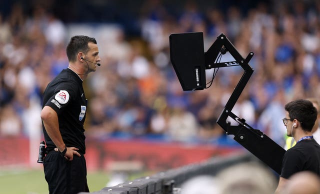Referee Andrew Madley consults the pitch side monitor before disallowing Cornet's equaliser