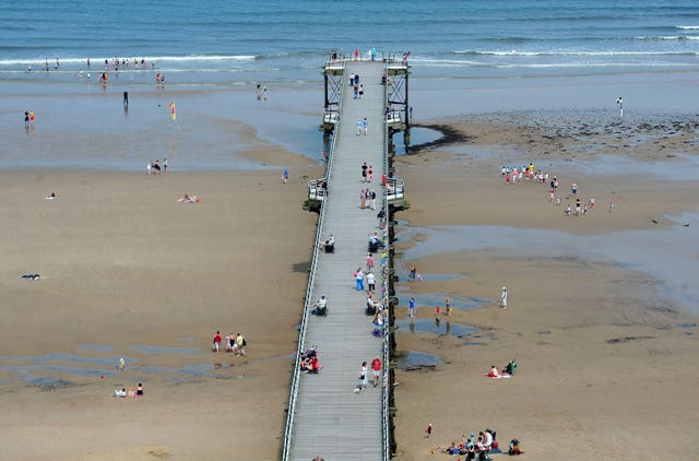 Families walk on Saltburn Pier at Saltburn-by-the-Sea beach in North Yorkshire