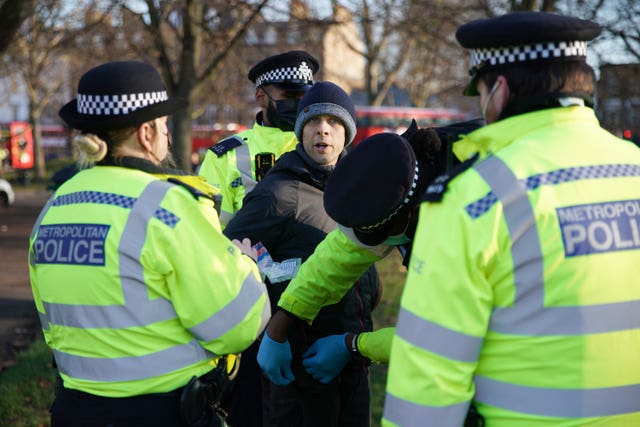 Police detain a man during an anti-lockdown protest in Clapham Common, London, on Saturday
