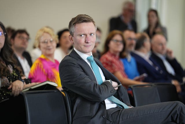 Torsten Bell looking to the right while seated in an audience