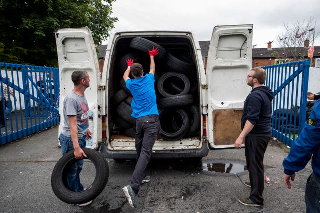 Local people load tyres into a van