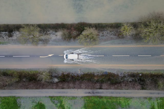A vehicle is driven along a flooded road between Quorn and Mountsorrel in Leicestershire