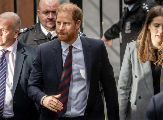 The Duke of Sussex walking outside among a group of people