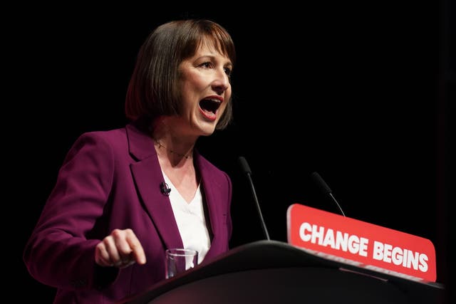 Rachel Reeves making a speech behind a podium with the words 'change begins' on it