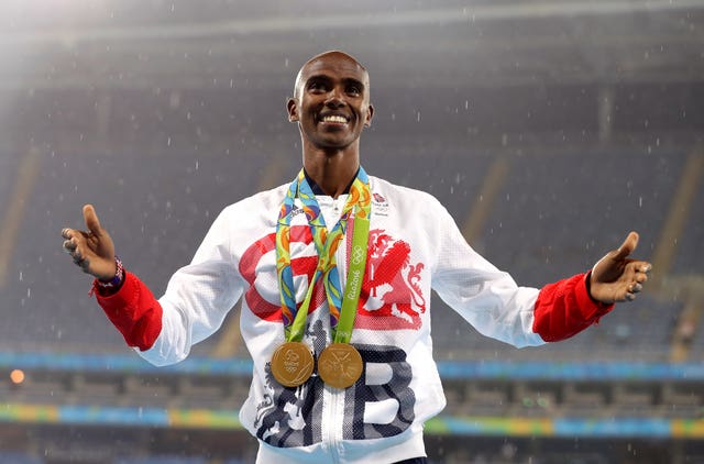 Great Britain’s Mo Farah celebrates with his gold medals