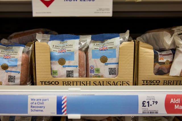 Tesco own-brand sausages with QR codes on their packages sitting on a shelf in the supermarket