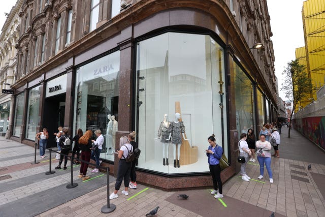 People queue at the entrance of fashion chain Zara in Belfast