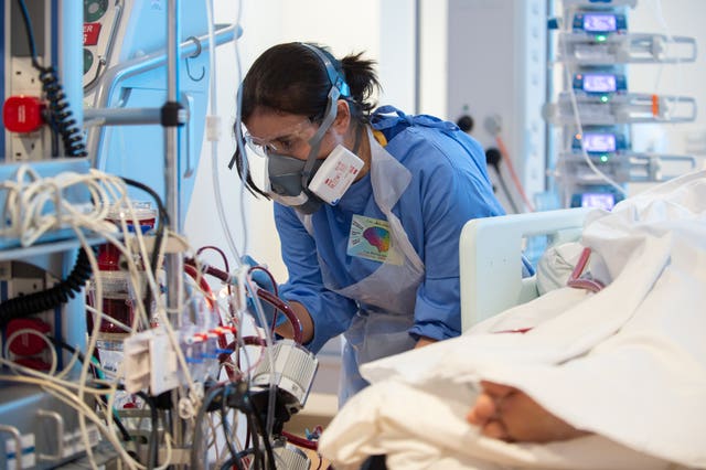 Lisa Fontes checks on a patient suffering with Covid-19 on the critical care unit at the Royal Papworth Hospital