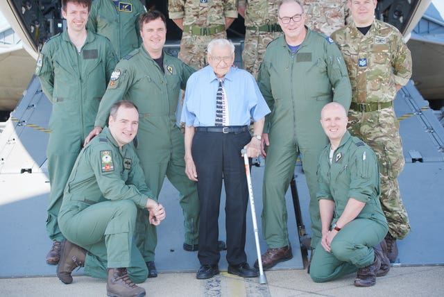 99-year-old Second World War RAF veteran Dennis Bishop, centre, accompanied by air crew of an Airbus A400M Atlas military transport aircraft at RAF Brize Norton