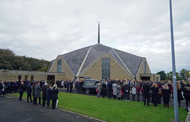 Mourners arrive at the church