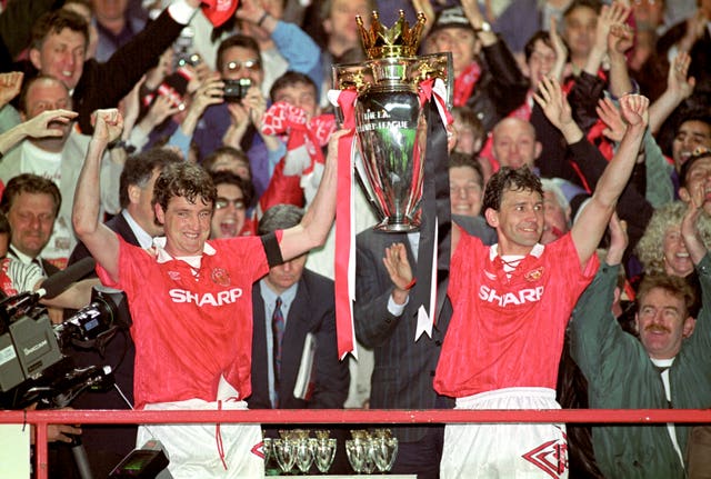 Manchester United players Steve Bruce, left, and Bryan Robson lift the Premier League trophy at the end of the competition's inaugural season in 1993