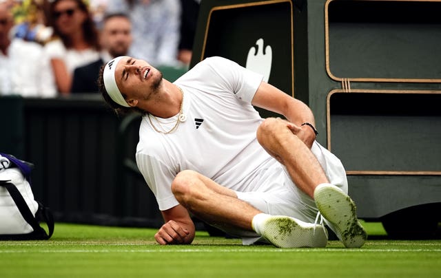 Alexander Zverev holds his left knee after a fall 