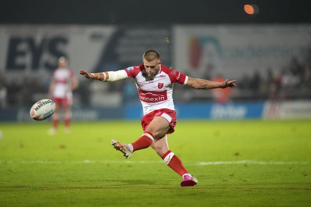 Hull KR half-back Mikey Lewis, with his left foot, kicks the ball towards the posts