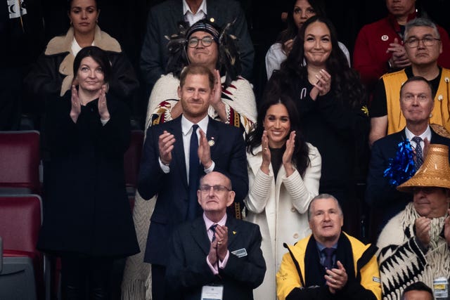 The Duke and Duchess of Sussex react as athletes arrive at the opening ceremony