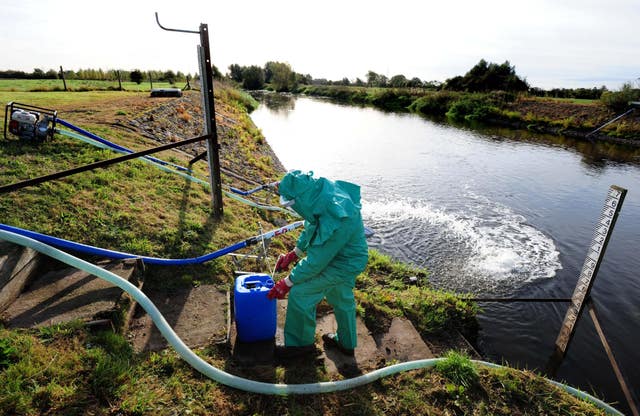 An Environment Agency worker treats the River Trent at Yoxall, Staffordshire