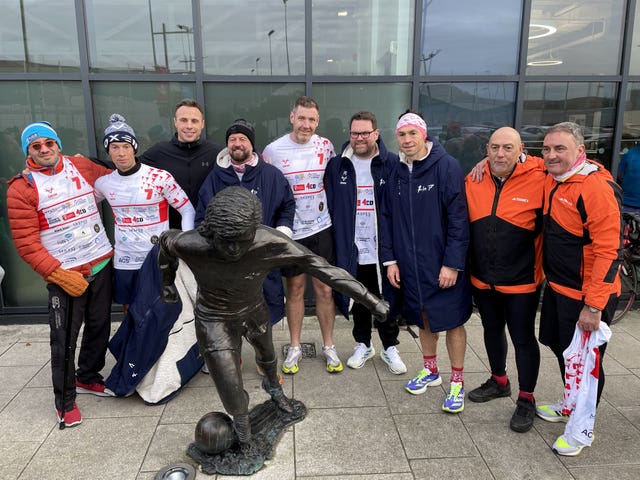 Kevin Sinfield, former rugby union player Tommy Bowe and others pose with a statue of George Best at the Olympia Leisure Centre at Windsor Park in Belfast