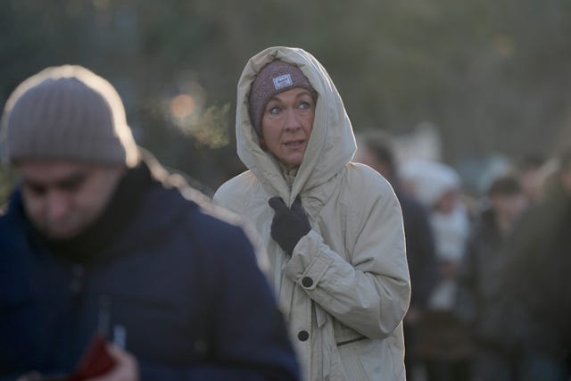 A woman wrapped up in hat and hooded jacket