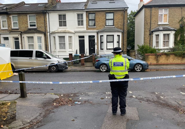 A Metropolitan police officer stands near a police cordon and forensic tent on Paget Terrace, near the scene in Eglinton Road