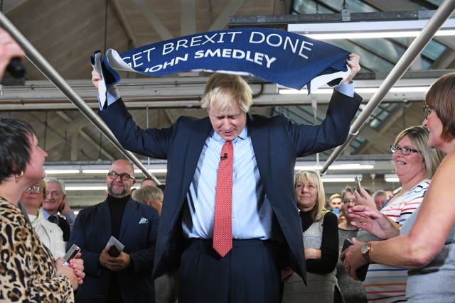 Boris Johnson with a Get Brexit Done banner at the John Smedley Mill in Matlock