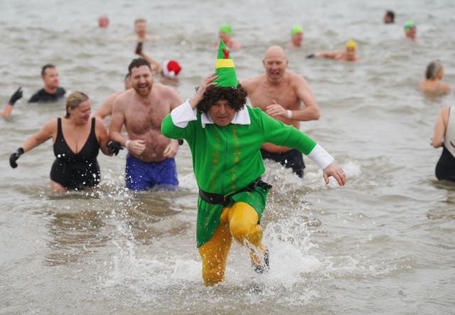 A man dressed as a Christmas elft runs out of the water at Bray in Co Wicklow