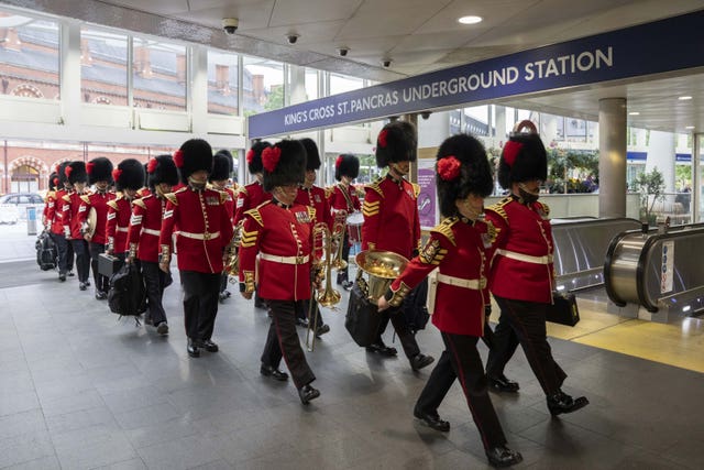Members of The Coldstream Guards march through King's Cross