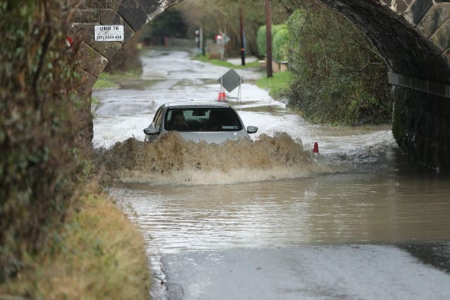 A car makes it way along a flooded road beneath a railway bridge on Piltown Road in Bettystown, Co Meath