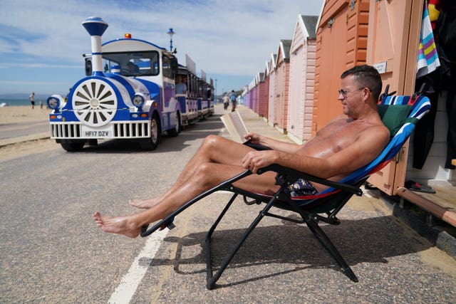 Stuart Henderson enjoys sunshine from his hut on Bournemouth beach 