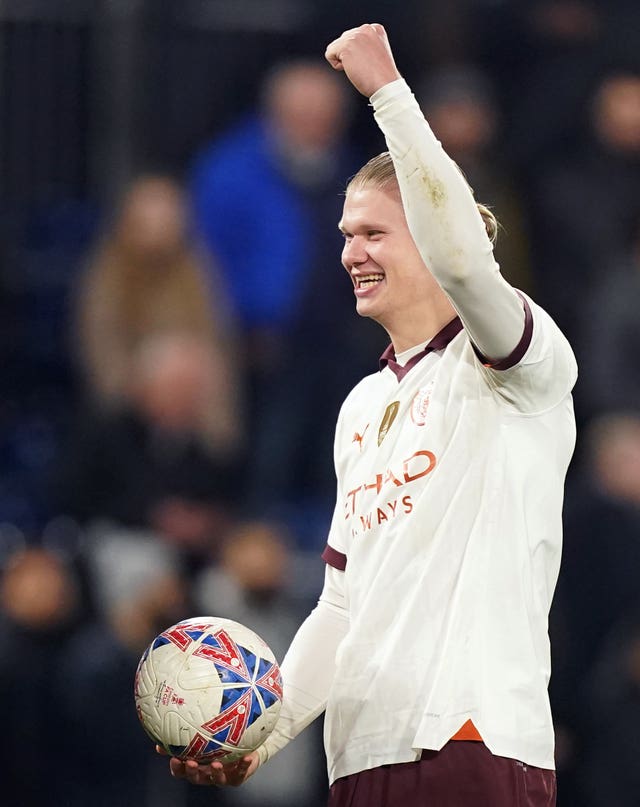 Erling Haaland celebrates with the match ball after scoring five goals in Manchester City's win over Luton