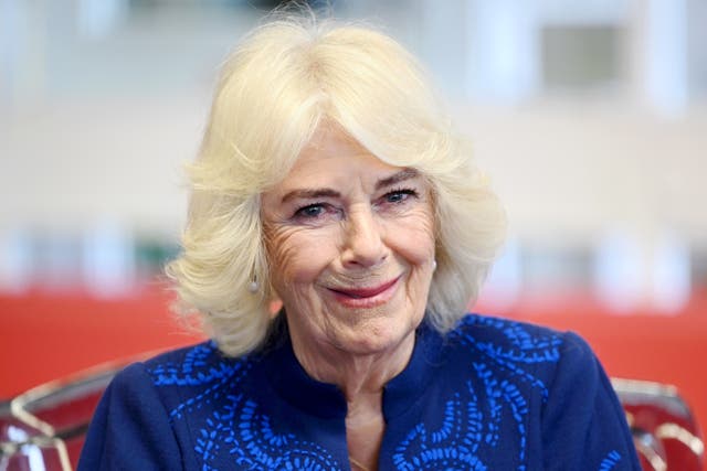 Camilla smiles while visiting a library