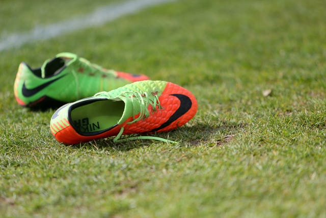 A pair of football boots on a pitch (Richard Sellers/AP)