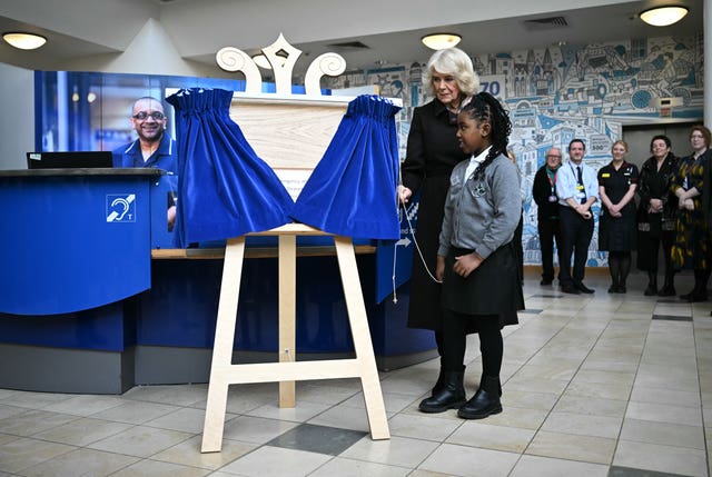 Camilla and nine-year-old Latoyah Vashi unveil a plaque to mark the Royal visit (Ben Stansall/PA)