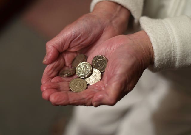 Hands of an elderly woman holding coins