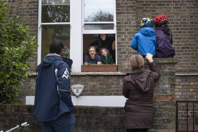 Two families maintain social distancing while talking to each other 