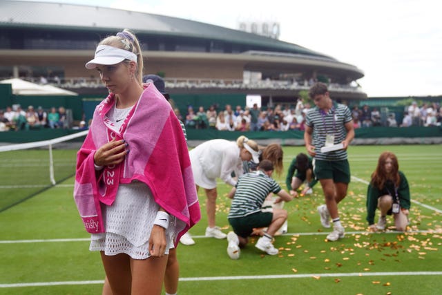 Katie Boulter looks on as ground staff clear confetti from Court 18 