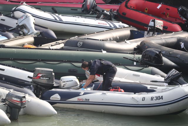 A Border Force officer attends to a collection of ribs and dinghys, thought to have been used in small boat incidents in the English Channel (Gareth Fuller/PA)