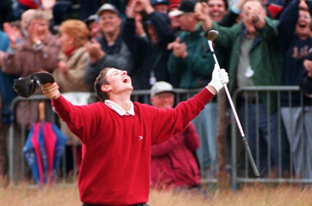 Justin Rose raises his arms aloft in celebration