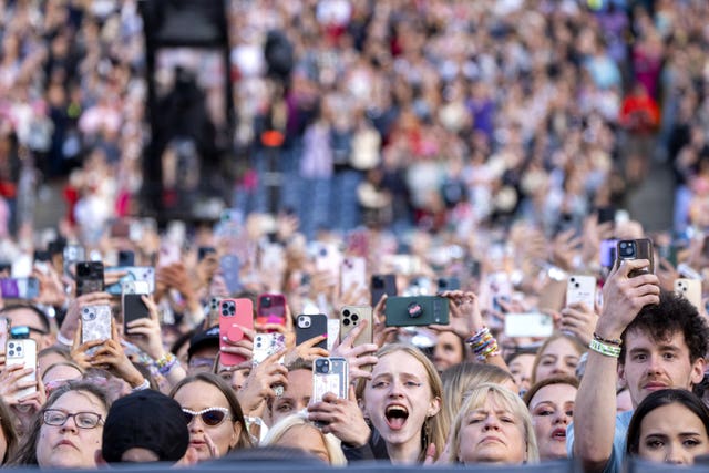 Music fans hold their mobile phones in the air as they watch Taylor Swift perform on stage during her Eras tour at Murrayfield Stadium in Edinburgh on June 7 