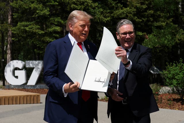 US President Donald Trump holding a UK-US trade deal with Prime Minister Sir Keir Starmer while speaking to the media at the G7 summit in Canada in June 2025