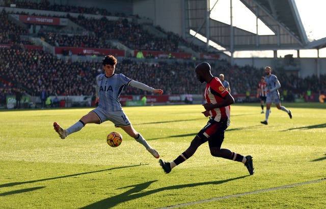 Tottenham's Archie Gray, left, stretches to block Yoane Wissa's cross