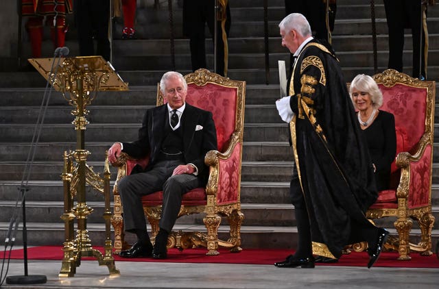 Speaker of the House of Commons Sir Lindsay Hoyle walks past King Charles III and the Queen Consort at Westminster Hall, London