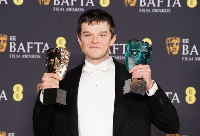 Robert Aramayo poses with the leading actor award for I Swear and the EE Rising Star Award during the 79th British Academy Film Awards, at the Royal Festival Hall, Southbank Centre, London