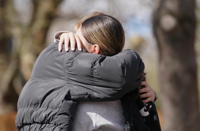 People hug at the scene in Beckton