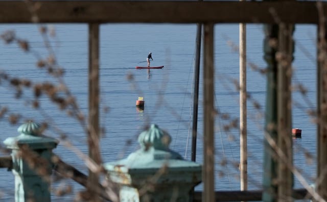 A person paddle boards in the sea off of Brighton Beach
