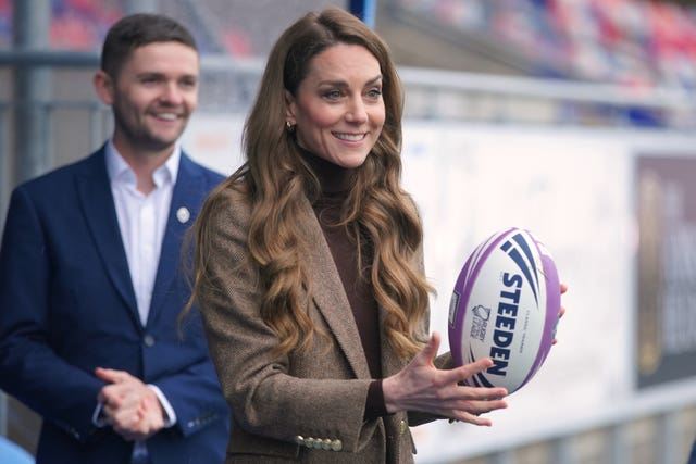 The Princess of Wales holds a rugby ball 