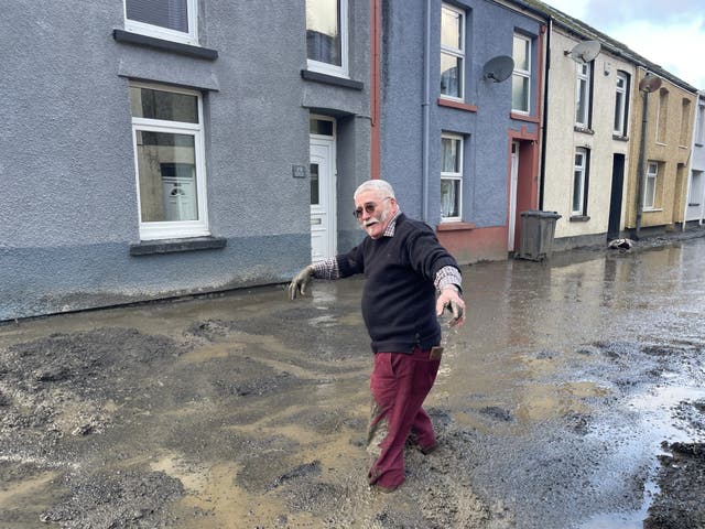 A man walking through muddy floodwater