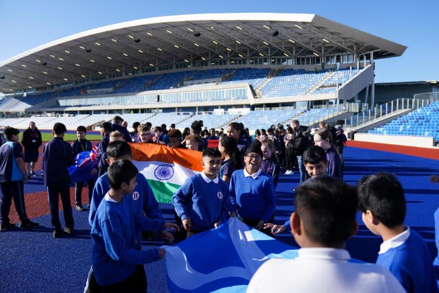 Pupils from schools in Birmingham carry Commonwealth member nations flags at the Alexander Stadium