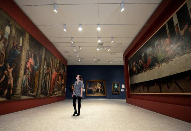 A visitor looks at works by Sir James Thornhill (left), copies of paintings by Raphael, and a copy of Leonardo da Vinci’s The Last Supper (right), at the launch of the new Royal Academy (Kirsty O’Connor/PA)